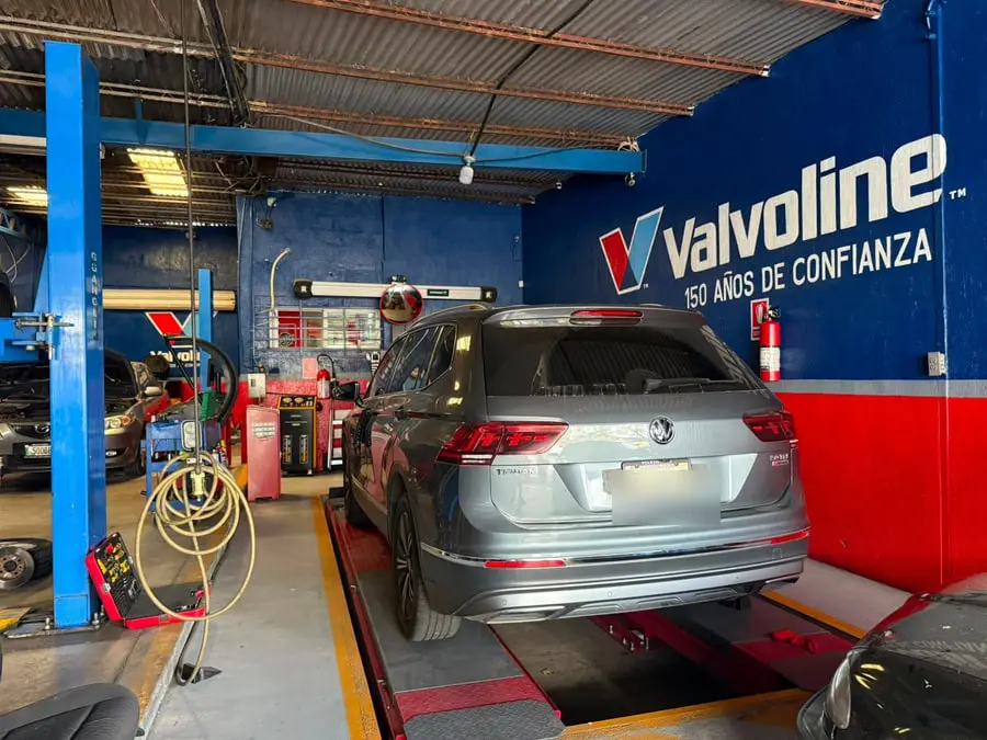 Volkswagen Escarabajo azul sobre la rampa de alineación con los platos giratorios colocados