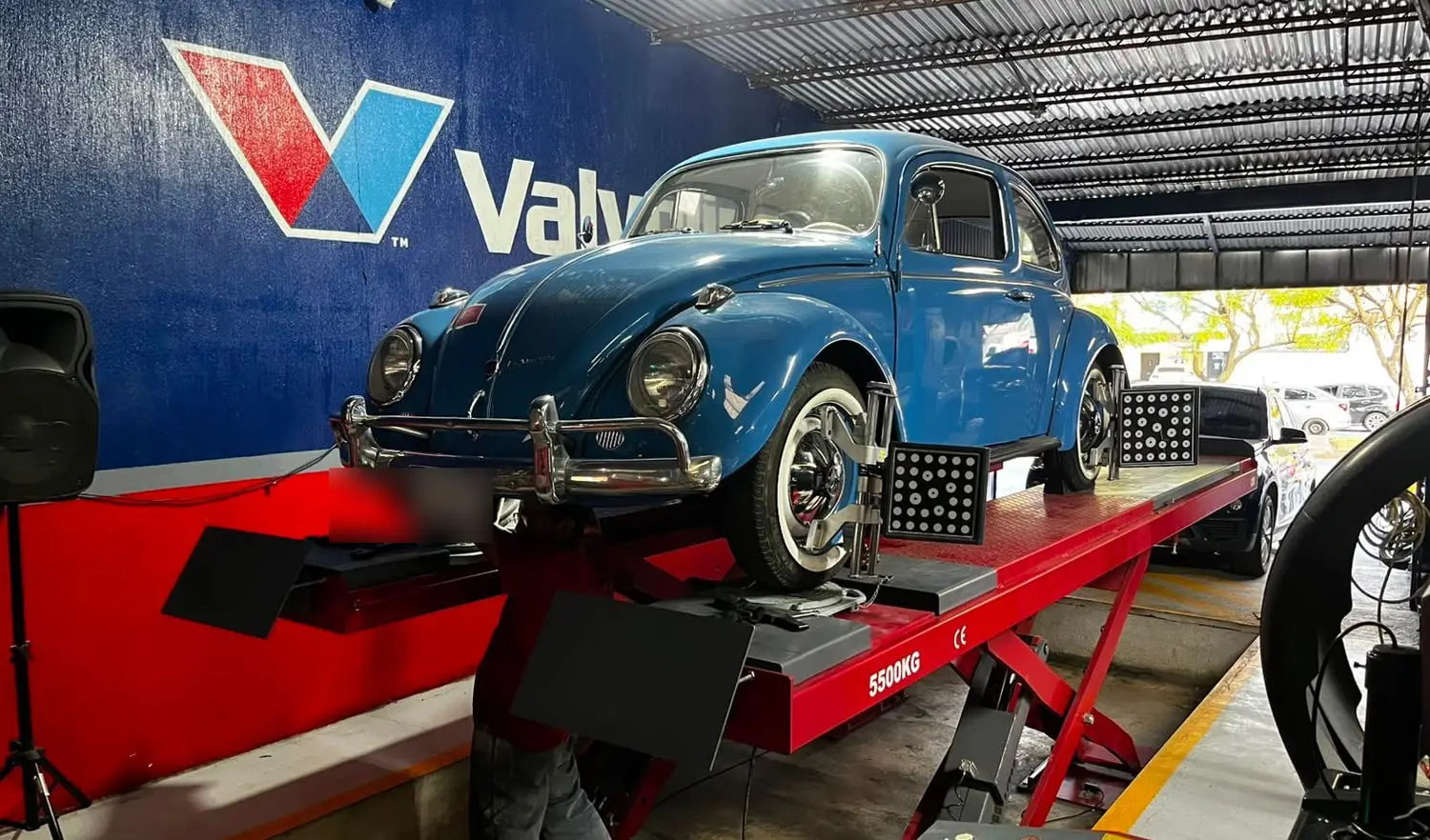 Camioneta SUV plateada sobre la rampa de alineación del taller